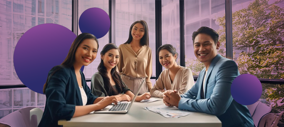 A diverse group of ASTICOM professionals collaborating in a modern office setting, exemplifying teamwork and strategic planning. They are engaged in a discussion, with one person using a laptop, highlighting the role of effective staffing solutions in enhancing operational agility.